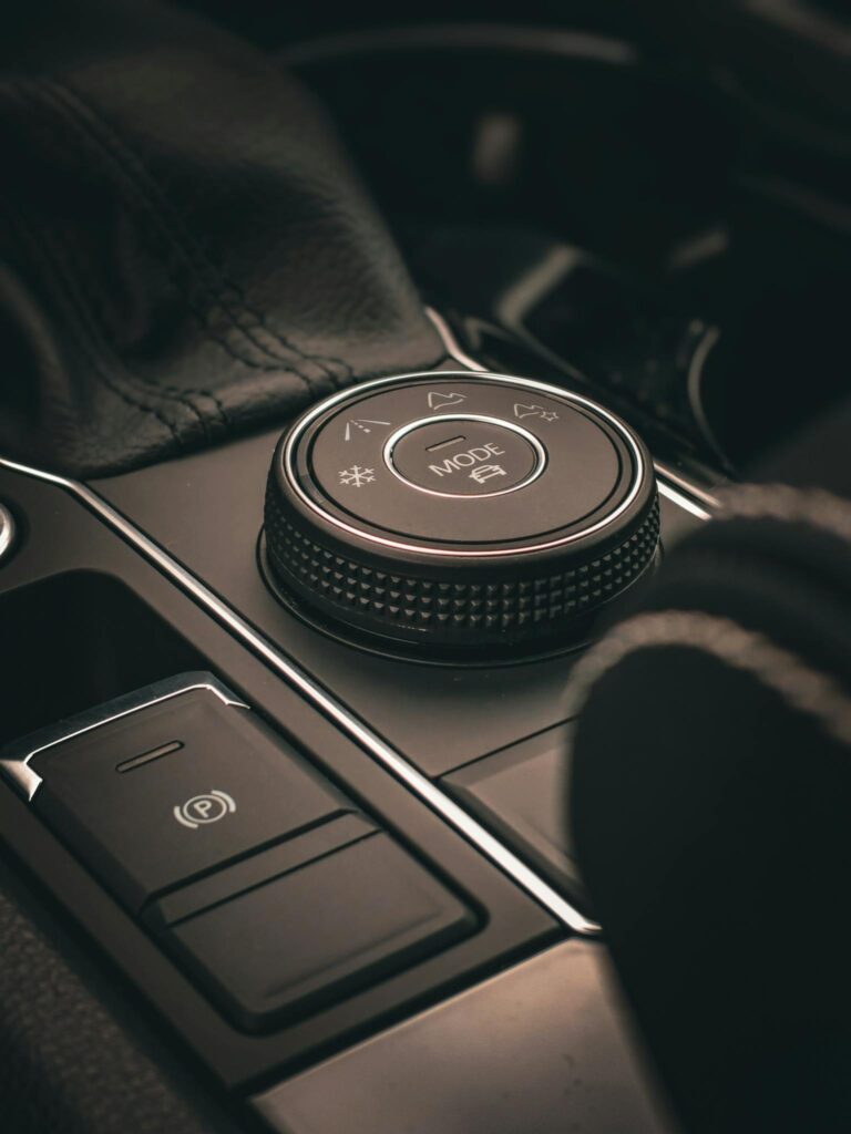 Close-up of a luxurious car interior control knob, highlighting modern automotive design.