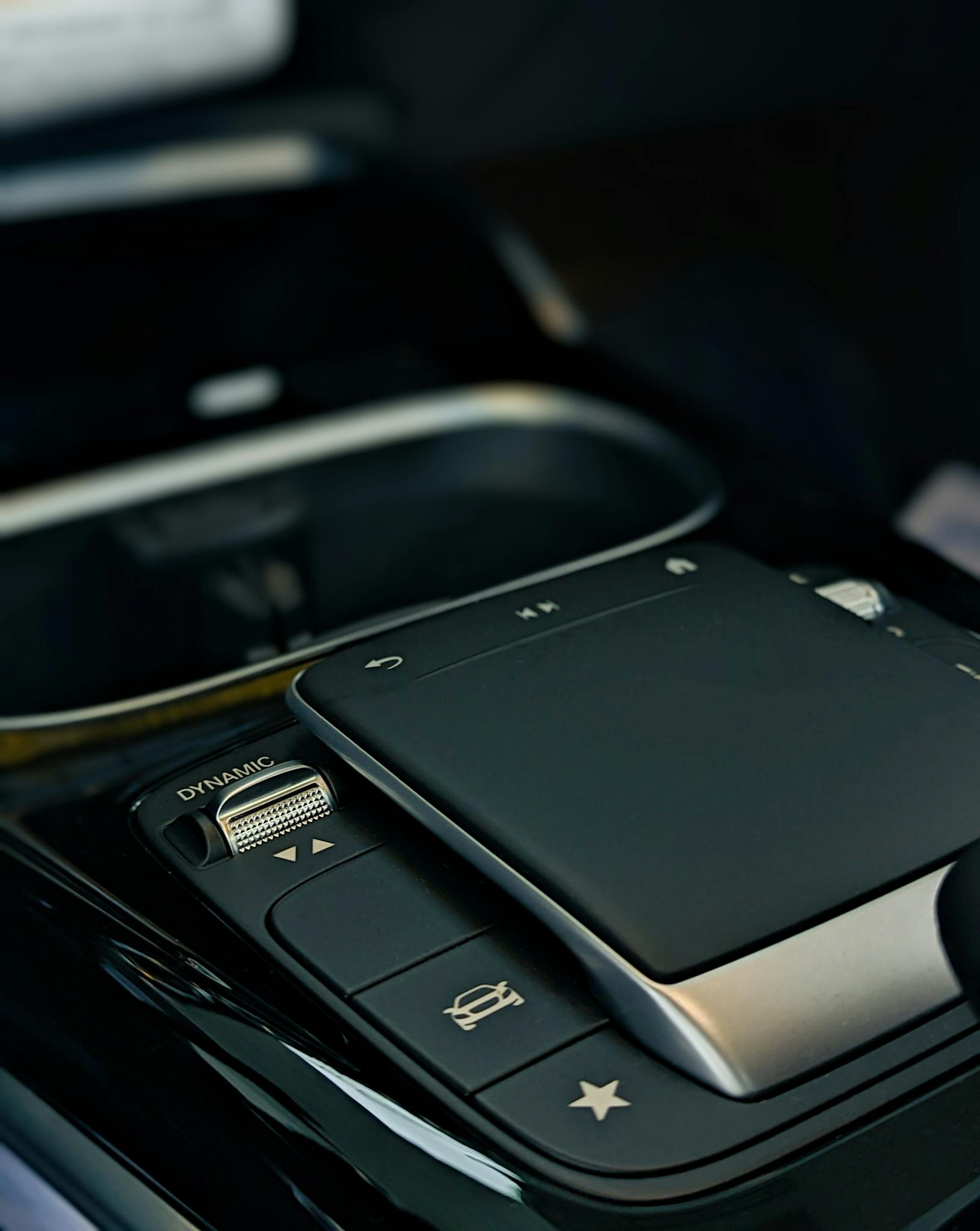 Detailed image of a sleek modern car control panel with touchpad and control buttons.