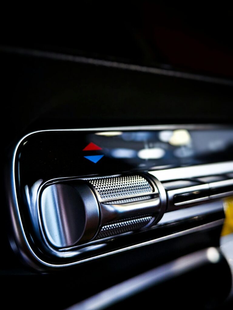 Detailed view of a car's air conditioning control knob and panel, emphasizing modern design.